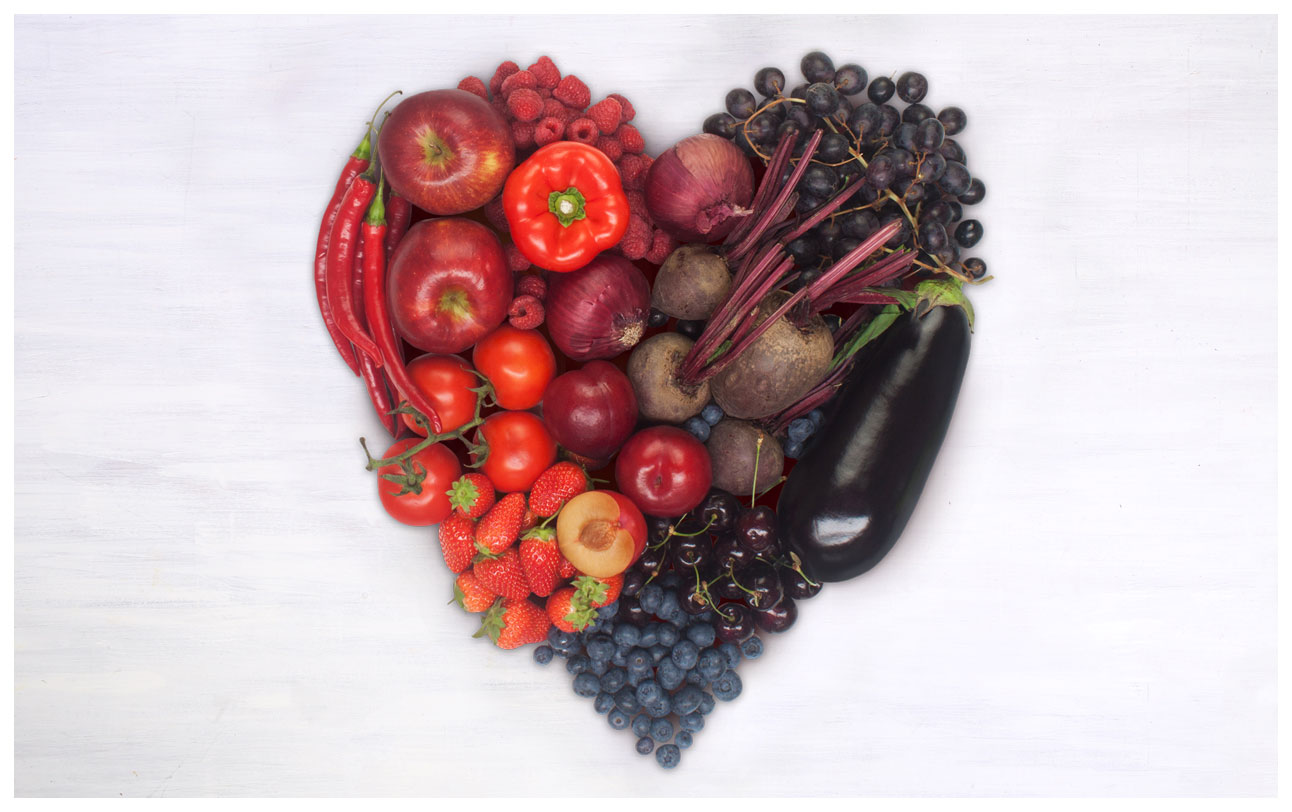 A photograph of a heart made out of red and purple fruit and veg