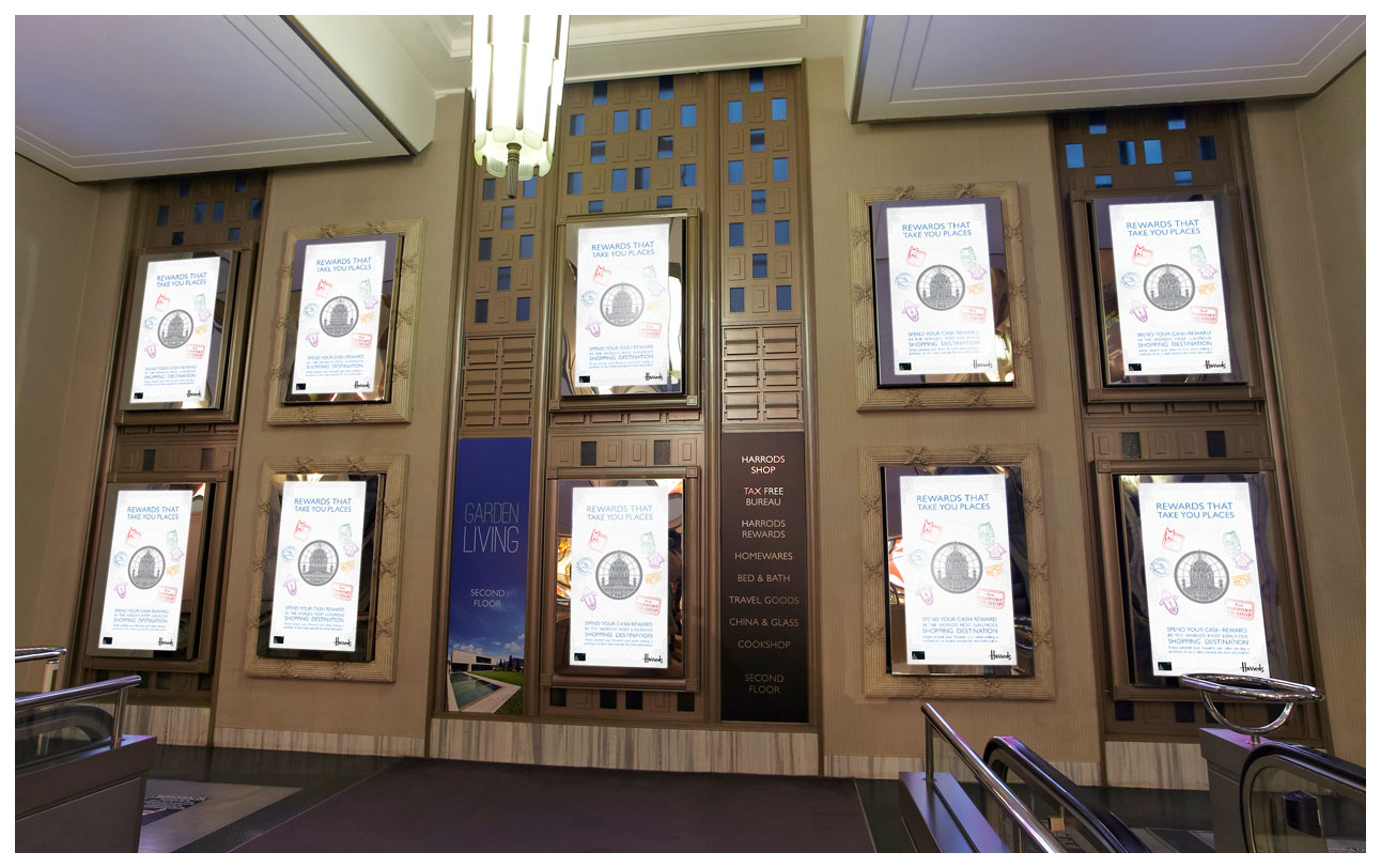 A photograph of a bank of plasma screens showing digital campaign signage