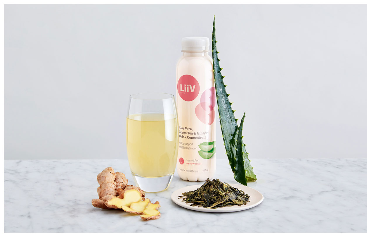 A still life photograph of a Liiv aloe vera drink bottle, a glass of the drink and it's ingredients